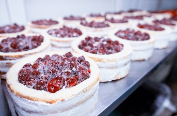 Making biscuit cakes with condensed milk in the confectionery industry with fresh cherry, food industry, sweetness