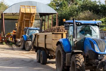 A tractor with a full trailer of crop waiting to unload back at the farm
