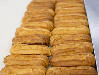 Fresh custard eclairs cakes lie on the table, background, pastry, handmade