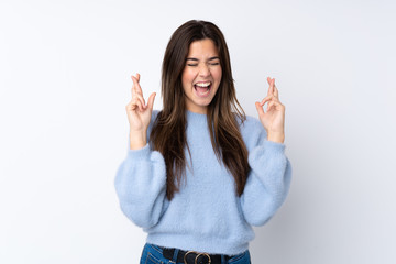 Teenager girl over isolated white background with fingers crossing