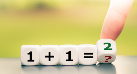 Teaching mathematics. Hand turns a dice and solves and equation.