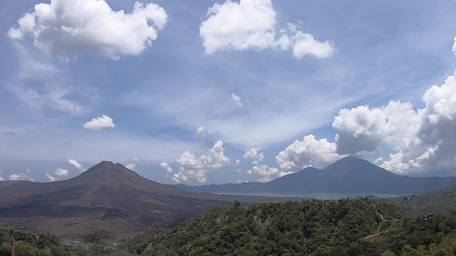 Volcanic hills in north Bali with time lapsed clouds racing through the blue sky