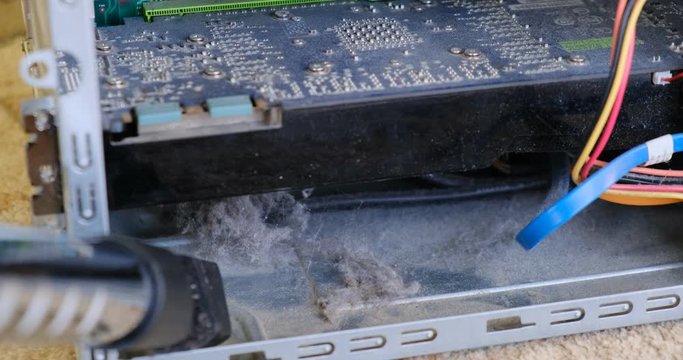 Vacuuming dust from inside a computer case using a regular vacuum cleaner.