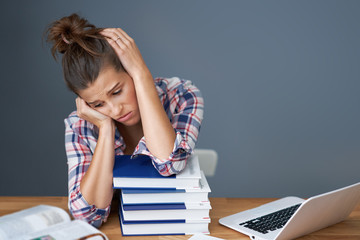 Tired female student learning till late at home