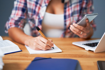 Midsection of female student learning at home