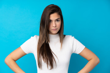 Teenager girl over isolated blue background angry