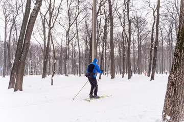 Fototapeta na wymiar Girl in the park in winter is engaged in running
