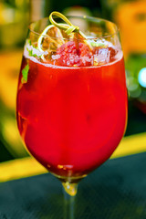 Cocktail with dried lemon, raspberries and ice on the bar.