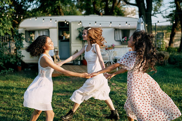 Happy beautiful women dancing in circle during a picnic
