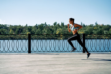 Sporty woman running outdoors by river