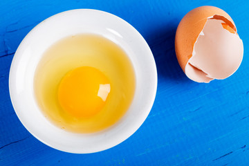 Bright yellow egg yolks in a white bowl 