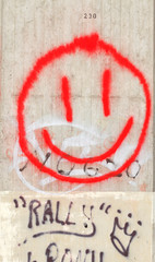 Roter lächelnder Smiley auf weissen Betonpfeiler gemalt