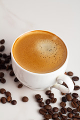 cup of coffee with beans on white background