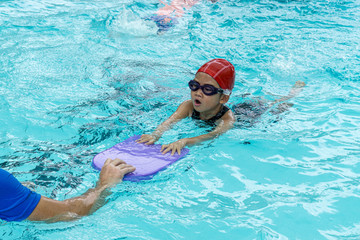 kids learn how to swim in swimming class