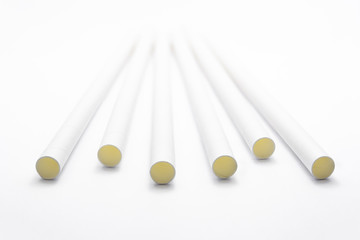 Close up white paper straws laying flat isolated on white background.