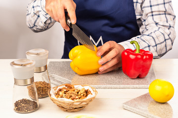 A section of bell pepper with a sharp knife on a cutting board made of artificial stone