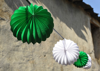 Farolillos de papel blanco y verde que decoran las calles de un pueblo español en fiestas
