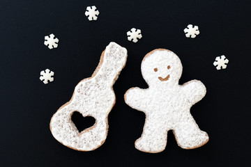 Music creative concept with sugared cookies - man and his guitar, decorated with small sugar snowflakes