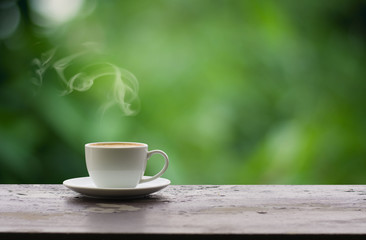 Coffee espresso on wood table nature background in garden,warm tone