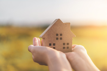 Small home model on woman hand.