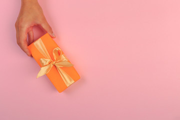 gift in female hands on a colored background top view. - Image