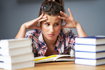 Tired female student learning till late at home