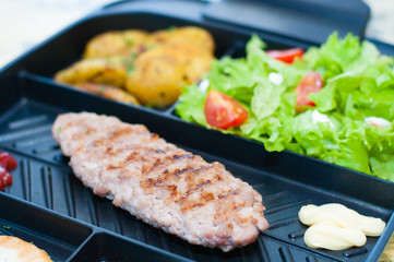 Fototapeta na wymiar Grilled steak or cutlet, salad with tomato and green vegetables, toast, potato plan, light background, copy space. Concept healthy eating, diet, menu, nutritious food.