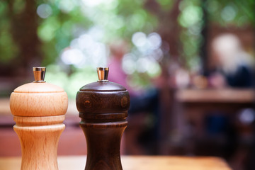 Wooden salt and pepper shakers on blurred defocused background. shallow depth of field and copy...