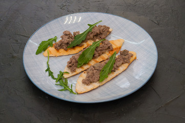 Croutons with paste and arugula. Festive appetizer, New Year's Italian dish