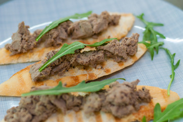 Croutons with paste and arugula. Festive appetizer, New Year's Italian dish. Side and top view, close-up