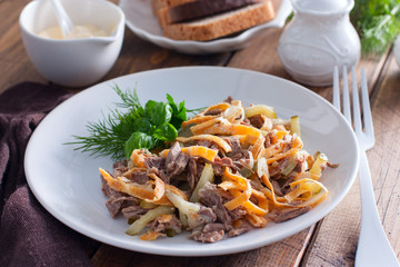 Minced salad of boiled beef and egg pancakes on a white plate, selective focus