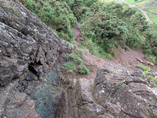 Iron deposit among a mis of igneous and granite rock of a mountain climbing path with shaggy green bushes © Rumpus