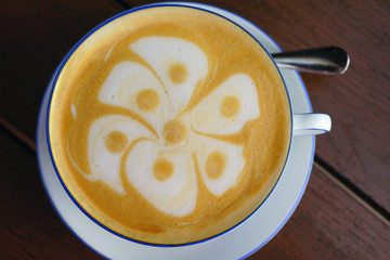 Cup of warm cappuccino coffee with a flower foam design on top