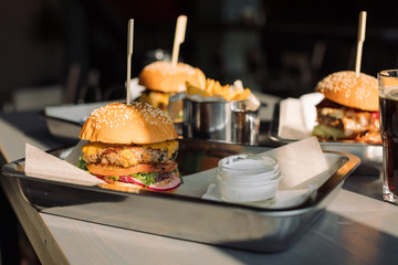 Tasty Burgers with French fries and  cream sauce on table.