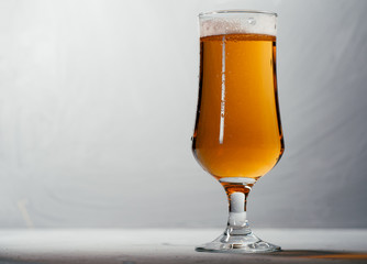 Glass of light beer lager on a dark background