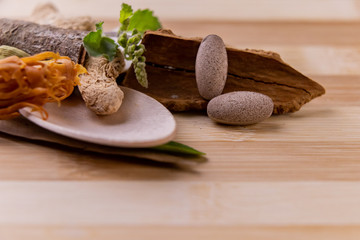 Top view macro shot of herbal pills and tablets arranged with spices on a red stone. Unani medicines concept.