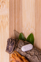 Top view macro shot of herbal pills and tablets arranged with spices on a red stone. Unani medicines concept.