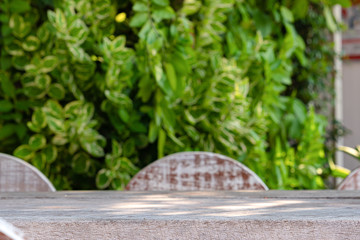 Empty wooden table for display of products in front of coffee shop abstract blur background