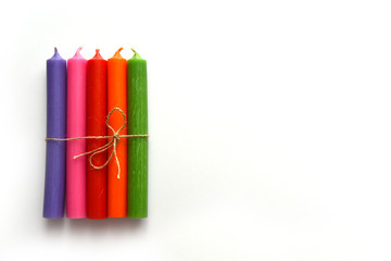 multi-colored long candles on a white background, top view close-up
