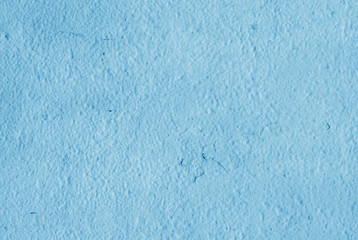 Cracked light blue paint on plaster.