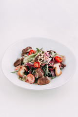  Cherry tomatoes on the grill. Restaurant serving salad. Salad with porcini mushrooms. Slicing fresh herbs.