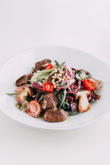  Cherry tomatoes on the grill. Restaurant serving salad. Salad with porcini mushrooms. Slicing fresh herbs.