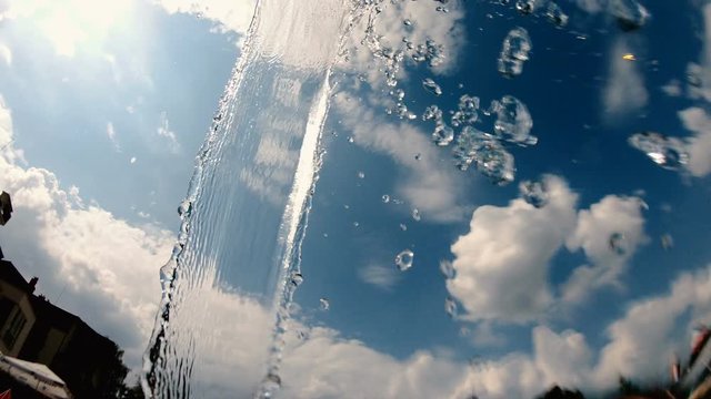Drops falling drom water jet in a pool, slow motion