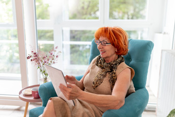 Senior woman surfing the Net on tablet computer