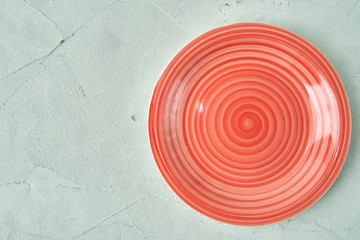 Fototapeta na wymiar round red plate on a birch concrete background