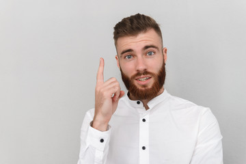 Image of bearded surprised man pointing finger upward