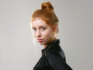 young girl with long red hair on a gray background