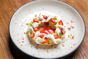 Beautifully decorated strawberry tart with lime meringue, exquisite restaurant dessert	