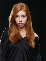 young girl with long red hair on a black background