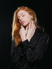 young girl with long red hair on a black background